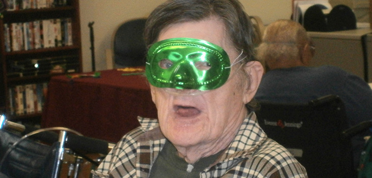 resident with green mardi gras mask