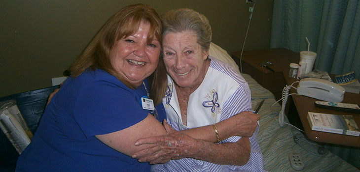 staff member embracing smiling resident